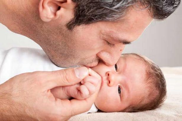 Padre con bebé recién nacido y palangana con ropa sucia, padre de baja por  paternidad, haciendo tareas domésticas y pasando tiempo con su hija,  aislado sobre una pared amarilla.