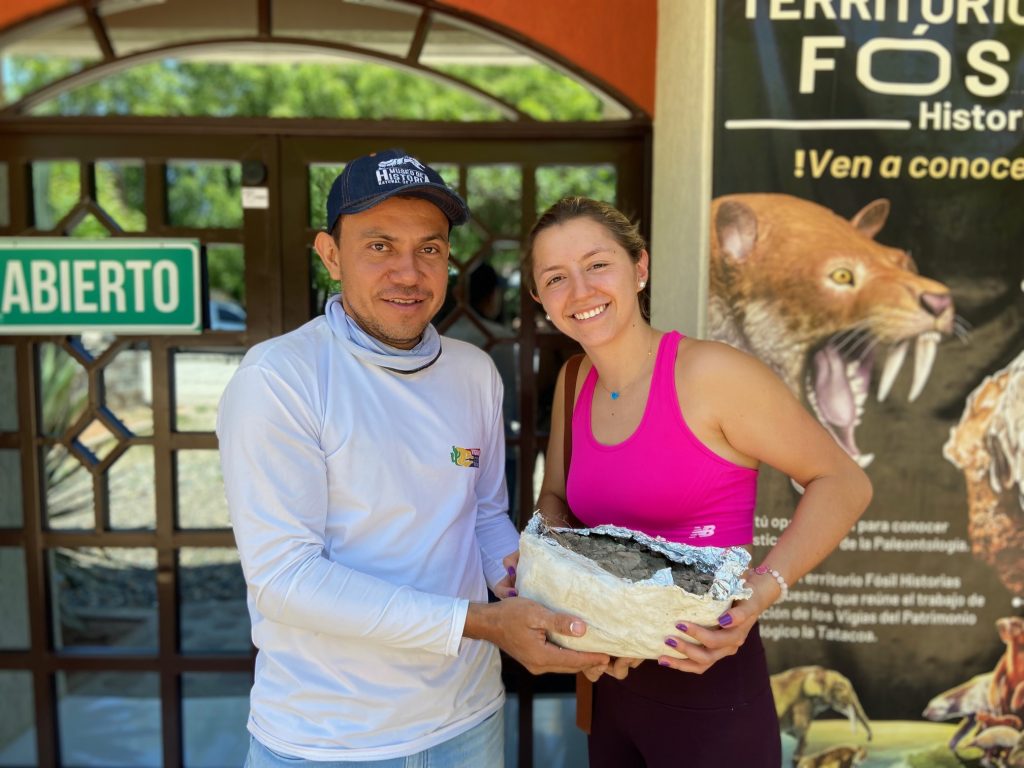 Lucía Vargas, estudiante javeriana, y Andrés Vanegas, fundador del Museo de Historia Natural La Tatacoa. Ambos sostienen el fósil de un oso perezoso que habitó este lugar hace 13 mil años. Foto cortesía Lucía Vargas. 