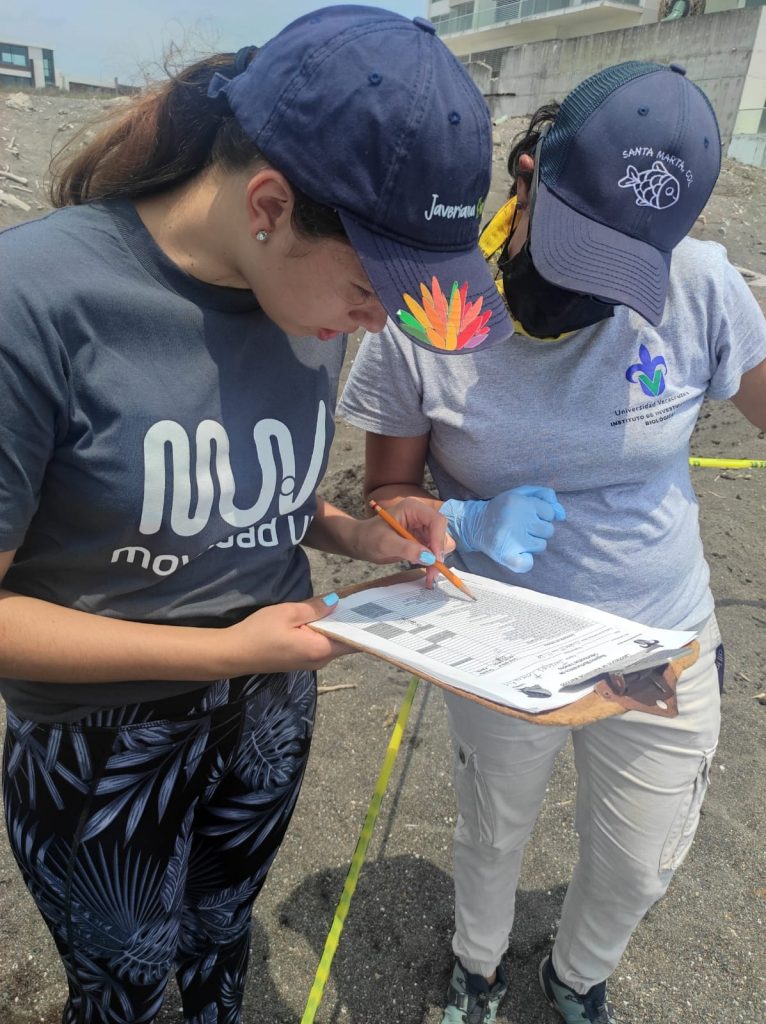 Angélica Flórez (izquierda) y la investigadora Dra. Isabel Hernández (derecha) en la costa de Veracruz haciendo protocolo de seguridad por varamiento de delfín / Fotografía cortesía de la estudiante