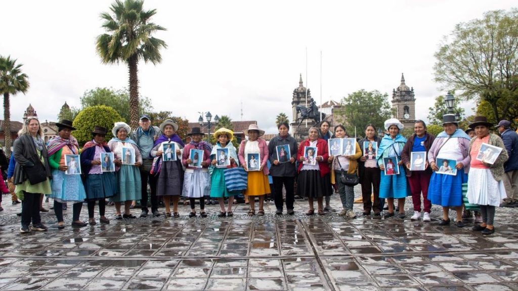 Mamitas sosteniendo sus retratos. Víctimas de la Anfasep de Perú, parte de la investigación que aún está en curso. Fotografía: archivos de la ANFASEP