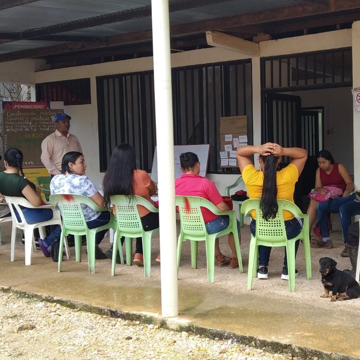 Reunión comunitaria al aire libre con participación de habitantes locales en actividades de salud.